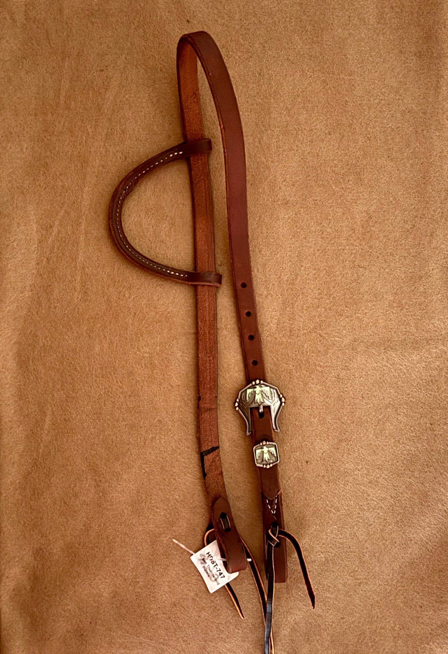 Slip ear bridle with green thunderbird buckle